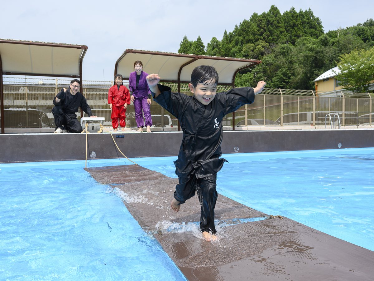 浮橋を走る黒い忍者衣装の子ども
